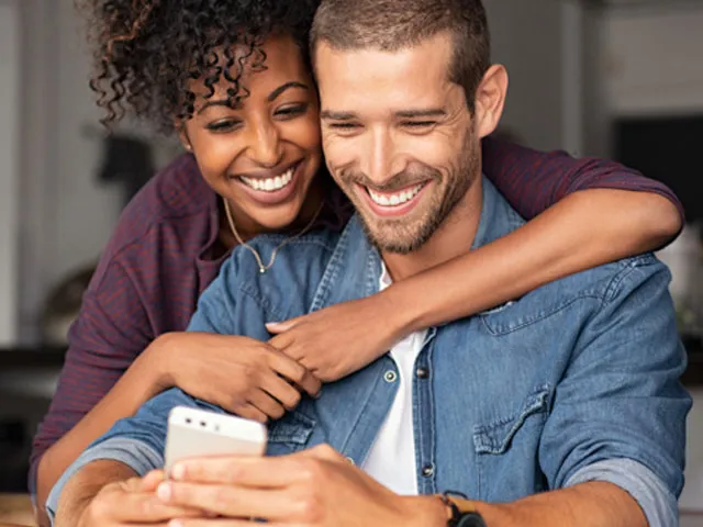 Casal a olhar para o telemóvel