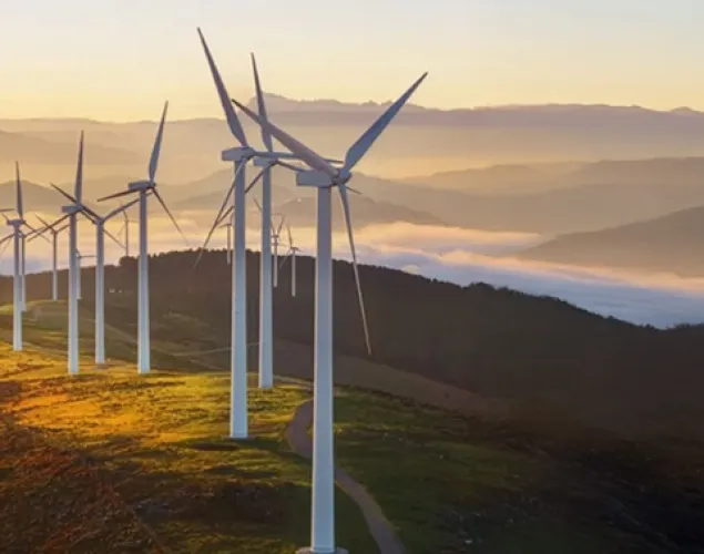Fotografia de uma colina com vários moinhos de energia eólica.