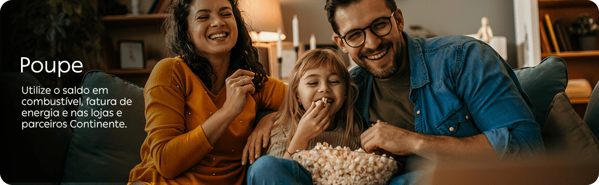 Família de três pessoas sentada num sofá em casa, num ambiente acolhedor ao fim do dia. Um homem e uma mulher sorriem enquanto uma criança come pipocas de uma taça ao centro. A cena transmite um momento de convívio familiar e conforto. À esquerda, sobre a imagem, surge o texto “Poupe” e a mensagem “Utilize o saldo em combustível, fatura de energia e nas lojas e parceiros Continente.